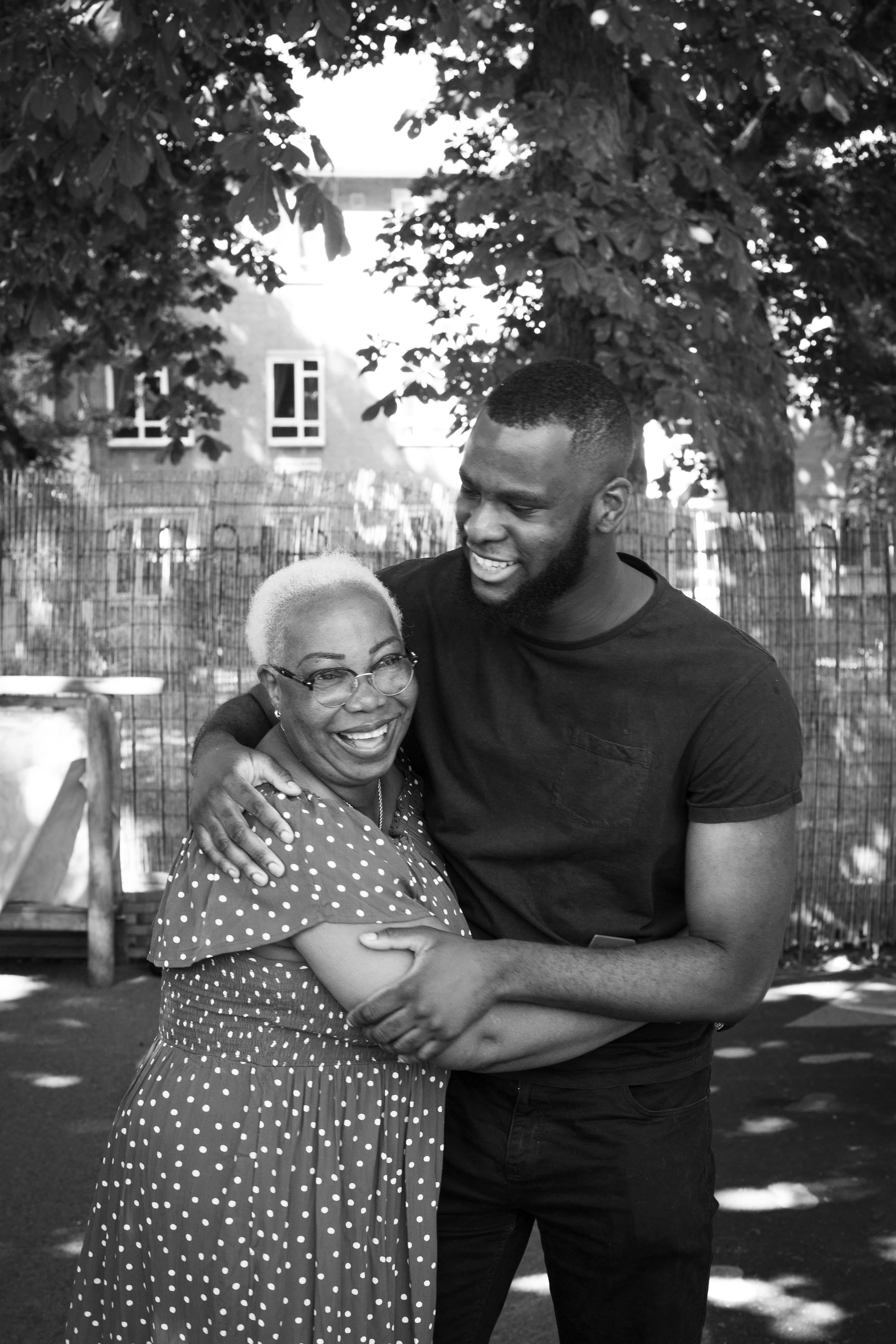 staff portrait of mum and son hugging outside
