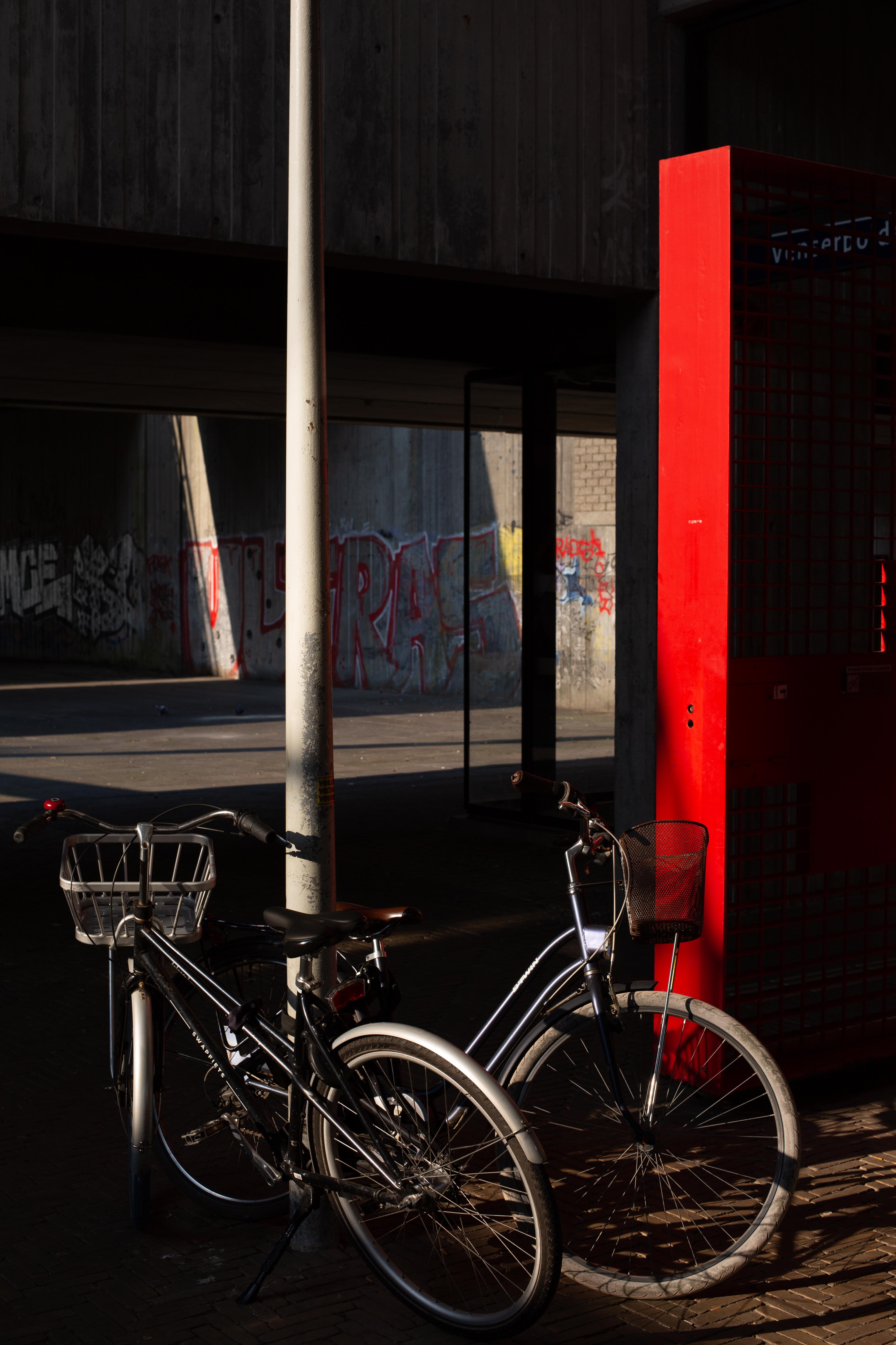 bikes in front of a red lit strip and graffiti in low light