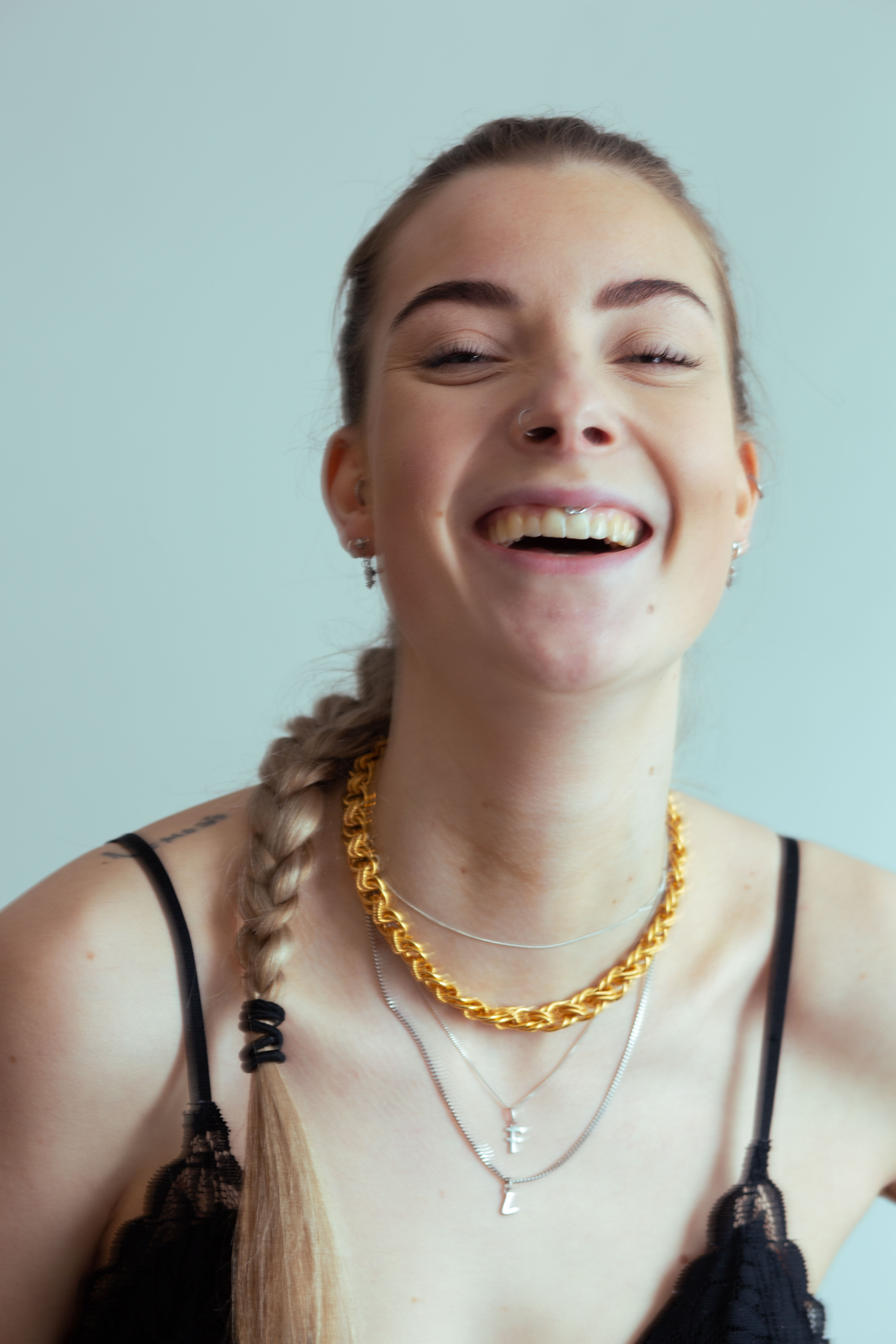 black and white portrait of blonde model with rose tattoo and chain necklaces